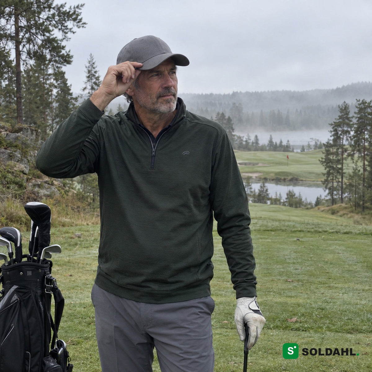 Golfspiller i grøn trøje, der justerer en grå kasket på en tåget golfbane