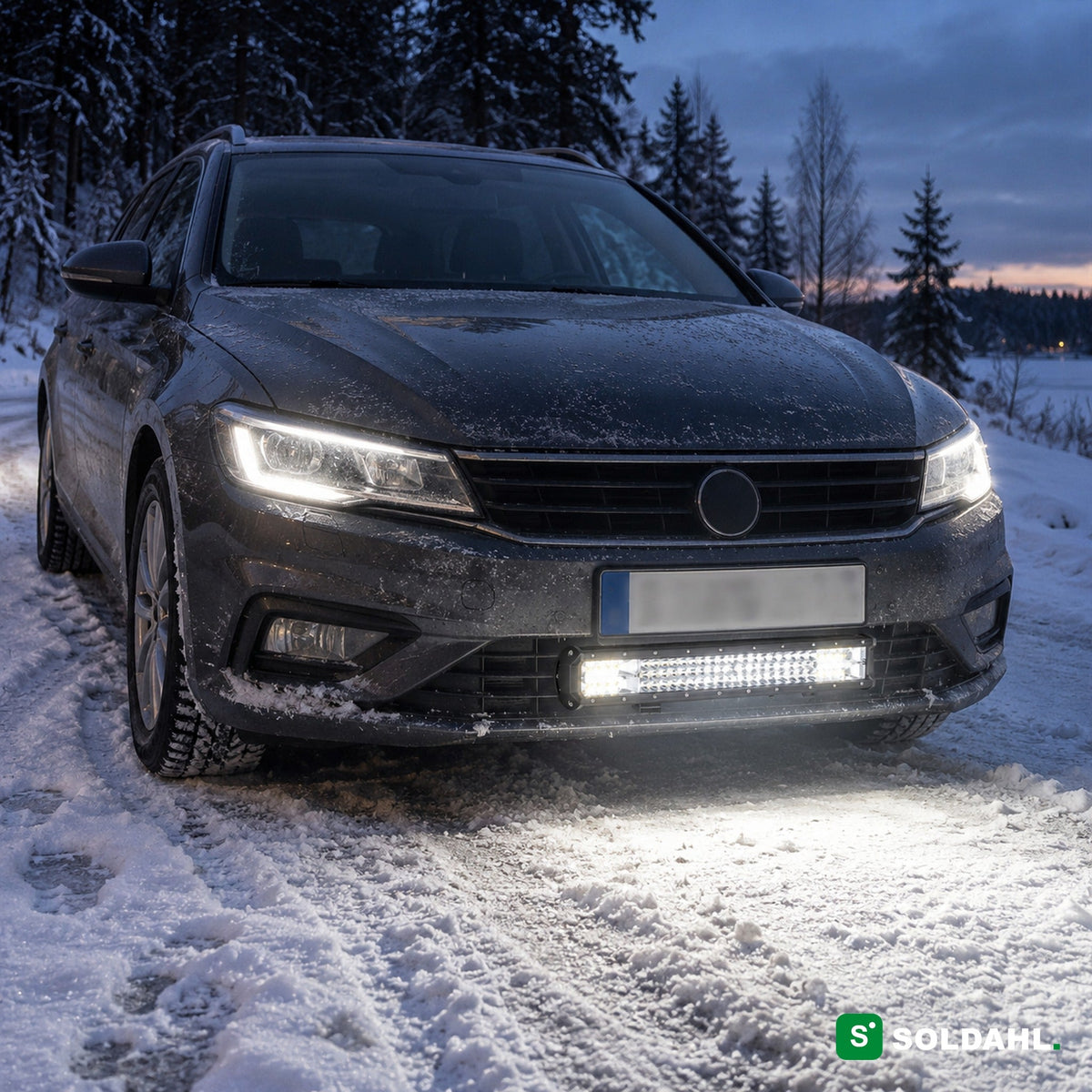 LED-lysbar monteret under kofangeren på en bil på en snedækket vej i skumringen