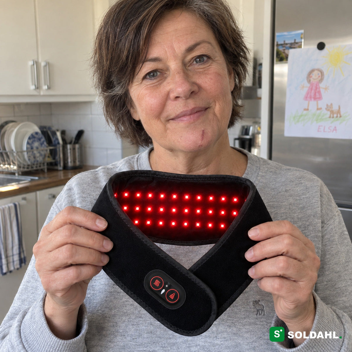 Kvinde holder nakkebåndet op, så de 36 røde lamper kan ses