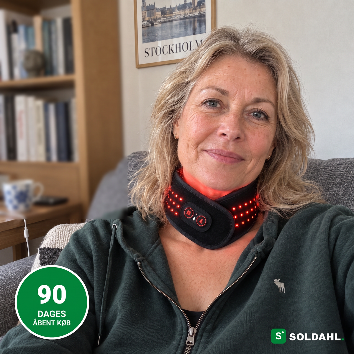 Kvinde i sofaen med Soldahl nakkebånd med rødt lys rundt om nakken