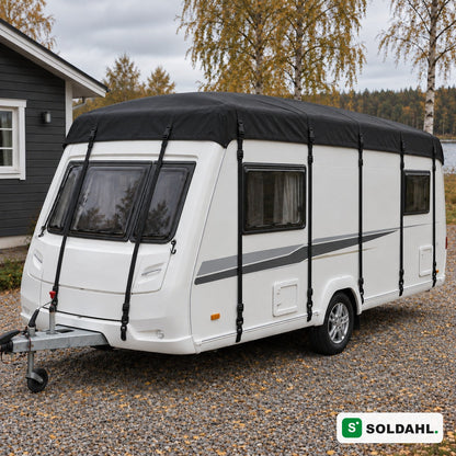 Sort tagbeskyttelse monteret på hvid campingvogn på grusindkørsel